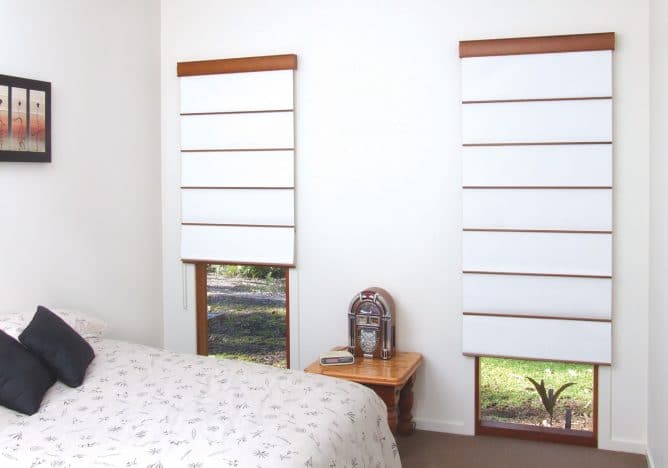 Two white roman blinds with wood treatment and white furnishings